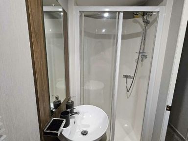 a bathroom with a shower and sink at Aberdunant Hall Holiday Park - Holiday Accommodation 22358, Porthmadog