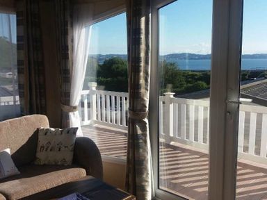 a seating area with large windows overlooking a body of water at Waterside, Paignton - Holiday Accommodation 2287, Paignton