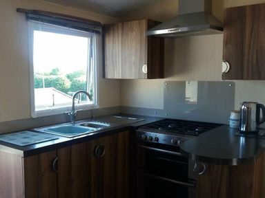 a kitchen with a window, stainless steel sink, stovetop, oven and kettle at Waterside, Paignton - Holiday Accommodation 2287