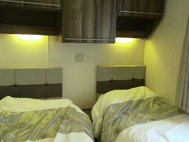 a bedroom with two beds and modern wall-mounted storage at Waterside, Paignton - Holiday Accommodation 2287 in Paignton