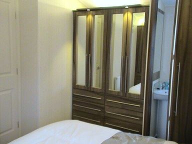 a wooden wardrobe with mirrored doors in a bedroom at Waterside, Paignton - Holiday Accommodation 2287, Paignton