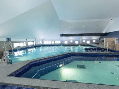 an indoor swimming pool with a hot tub and large windows at Waterside, Paignton - Holiday Accommodation 2287 in Paignton