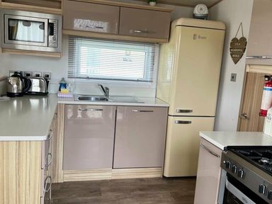 a kitchen with modern appliances and cabinetry at Lakeland Leisure Park - Holiday Accommodation 3166, Flookburgh