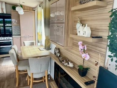 a dining area with a table and chairs in a modern kitchen at Lakeland Leisure Park - Holiday Accommodation 3166, Flookburgh