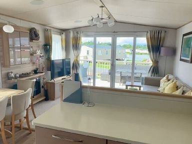 a living room with a television, seating area and dining table at Lakeland Leisure Park - Holiday Accommodation 3166, Flookburgh