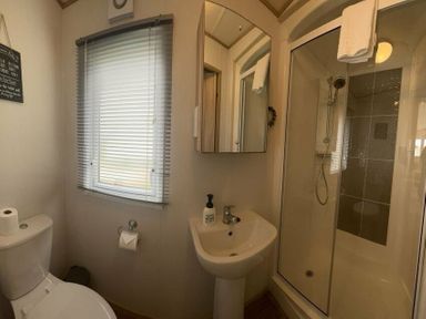 a bathroom with a shower, toilet, and sink at Lakeland Leisure Park - Holiday Accommodation 3166, Flookburgh
