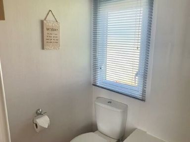 a bathroom with a toilet and window at Lakeland Leisure Park - Holiday Accommodation 3166, Flookburgh