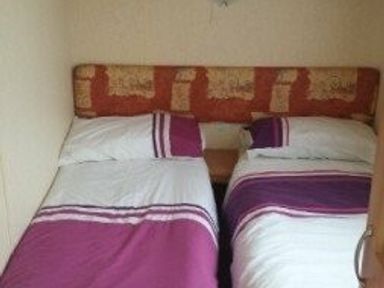 a bedroom with two twin beds and a headboard at Seven Bays Park (Maribou) - Holiday Accommodation 3966, St Merryn