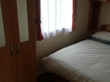 a bedroom with a bed and a wardrobe at Seven Bays Park (Maribou) - Holiday Accommodation 3966 St Merryn