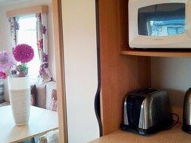 a kitchen area with a toaster and microwave on shelves at Swanage Bay View - Holiday Accommodation 464 in Swanage
