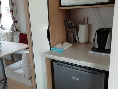 a kitchen area with a countertop, utensils, an appliance, and a seating area at Swanage Bay View - Holiday Accommodation 464, Swanage