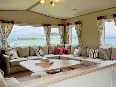 a seating area with a sectional sofa and a round table at St Andrews Holiday Park - Holiday Accommodation 609 St. Andrews