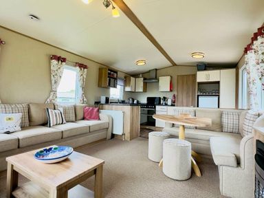 a living room and kitchen area with a sofa, dining table, and appliances at St Andrews Holiday Park - Holiday Accommodation 609 St. Andrews