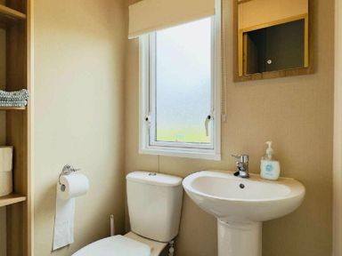 a bathroom with a toilet and sink near a window at St Andrews Holiday Park - Holiday Accommodation 609, St. Andrews