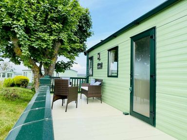 a green exterior of a holiday caravan with a small deck and seating area at St Andrews Holiday Park - Holiday Accommodation 609 St. Andrews