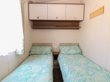 A bedroom with two beds and storage at Hopton Holiday Village - Holiday Accommodation 632 Hopton-On-Sea