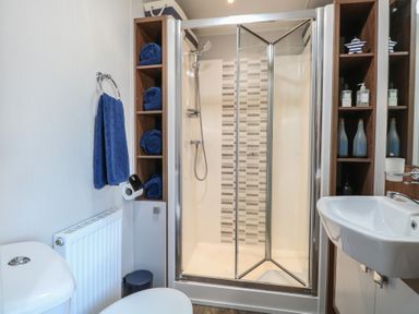 A bathroom with a shower, toilet, sink, and towels at Hopton Holiday Village - Holiday Accommodation 632 Hopton-On-Sea