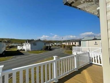a view from a balcony overlooking holiday homes and green landscape at Greenacres Holiday Park - Holiday Accommodation 6757 Porthmadog
