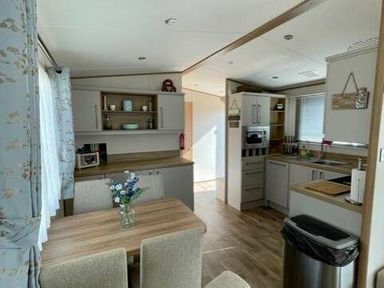 a kitchen and dining area with a table and chairs at Greenacres Holiday Park - Holiday Accommodation 6757 Porthmadog