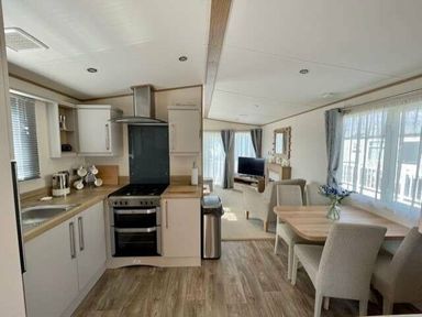 a kitchen and dining area with a table and chairs at Greenacres Holiday Park - Holiday Accommodation 6757, Porthmadog
