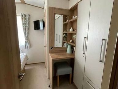 a hallway with a mirror and shelf leading to a bedroom at Greenacres Holiday Park - Holiday Accommodation 6757 in Porthmadog