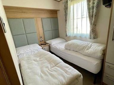 a bedroom with two single beds and a window at Greenacres Holiday Park - Holiday Accommodation 6757, Porthmadog