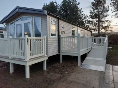 a holiday caravan with a ramp and wooden deck at Reighton Sands Holiday Park - Holiday Accommodation 6837 in Filey