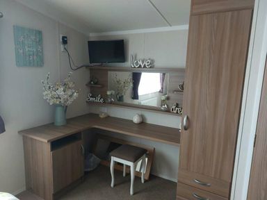 a corner dressing area with a mirror and storage at Reighton Sands Holiday Park - Holiday Accommodation 6837, Filey