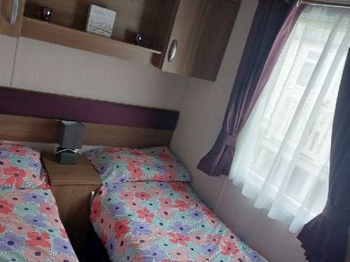 a bedroom with two beds and a window at Reighton Sands Holiday Park - Holiday Accommodation 6837 in Filey