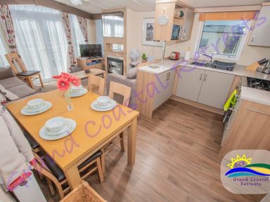 a dining area with a table set for meals in a kitchen and living space at Devon Cliffs Holiday Park - Holiday Accommodation 6955 Exmouth