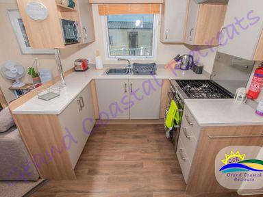 a kitchenette with cabinets, sink, stove, and appliances at Devon Cliffs Holiday Park - Holiday Accommodation 6955 in Exmouth