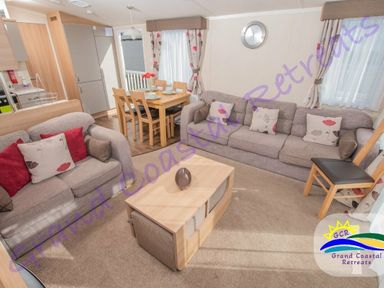 a living room with a sofa and dining area at Grand Coastal Retreats in Exmouth