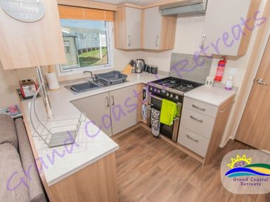 a kitchen featuring a sink, stove, and countertop at Grand Coastal Retreats in Exmouth
