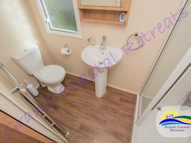 a bathroom with a toilet and sink at Grand Coastal Retreats