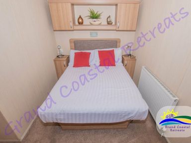 a bedroom with a double bed and bedside tables at Grand Coastal Retreats in Exmouth