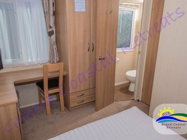 a bedroom with a desk and wardrobe at Grand Coastal Retreats in Exmouth