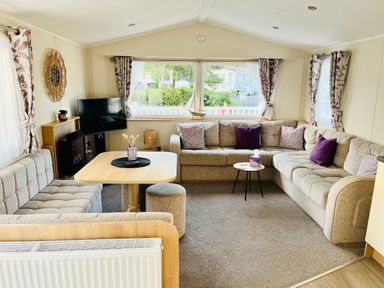 a living room with sectional sofas, a coffee table, and a TV at Hafan y Mor Haven - Holiday Accommodation 7421 Pwllheli