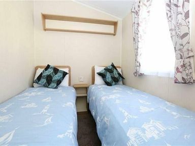 a bedroom with two single beds and a shelf in Hafan y Mor Haven - Holiday Accommodation 7421 Pwllheli
