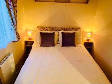 a bedroom with a double bed and bedside tables at Hafan y Mor Haven - Holiday Accommodation 7421 in Pwllheli