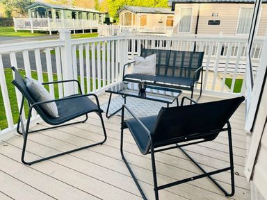 a seating area with black chairs and a table on a porch at Hafan y Mor Haven - Holiday Accommodation 7421 in Pwllheli