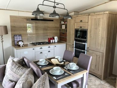 a kitchen area with dining table and four chairs at Perran Sands - Holiday Accommodation 7528, Perranporth, Cornwall, United Kingdom