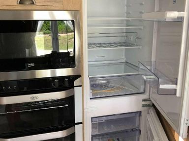 a refrigerator and oven combination with an open fridge and empty shelves at Perran Sands - Holiday Accommodation 7528, Perranporth, Cornwall, United Kingdom