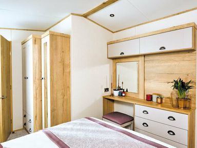 a bedroom with a mirror, dresser, and wardrobe at Perran Sands - Holiday Accommodation 7528, Perranporth, Cornwall, United Kingdom