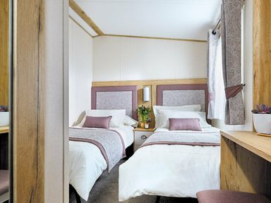 a bedroom with two twin beds, a nightstand and a writing desk at Perran Sands - Holiday Accommodation 7528, Perranporth, Cornwall, United Kingdom