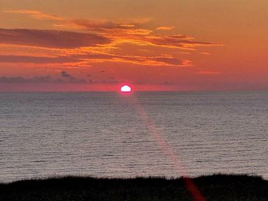 a sunset over the ocean with vibrant orange and pink colors at Perran Sands - Holiday Accommodation 8131, Perranporth