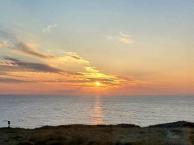 a sunset over the ocean with clouds at Perran Sands - Holiday Accommodation 8131 Perranporth