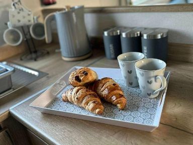a tray with croissants and two cups on a kitchen counter at Butlins Minehead - Holiday Accommodation 826 in Minehead