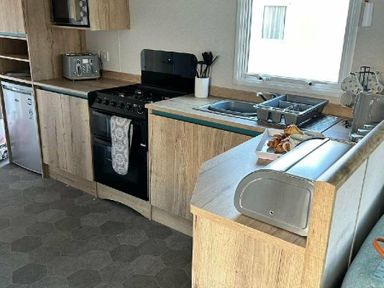 a kitchen with cabinets, stove, and sink at Butlins Minehead - Holiday Accommodation 826, Minehead