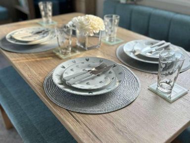 a dining table set with plates, utensils, and glasses at Butlins Minehead - Holiday Accommodation 826 in Minehead