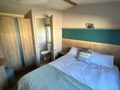 a bedroom featuring a bed, wardrobe, and an attached bathroom at Butlins Minehead - Holiday Accommodation 826 in Minehead
